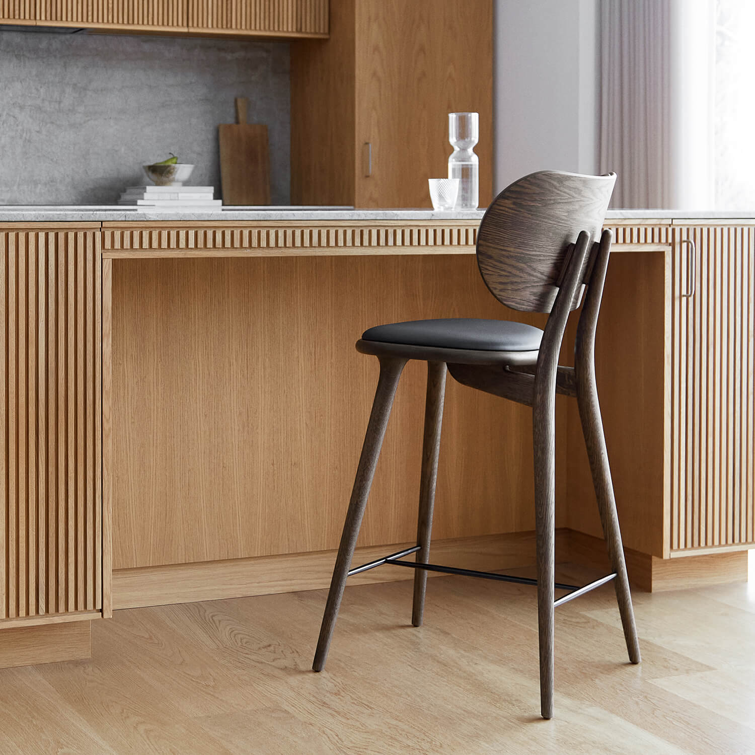 Wood bar stool with dark frame and leather seat in a kitchen