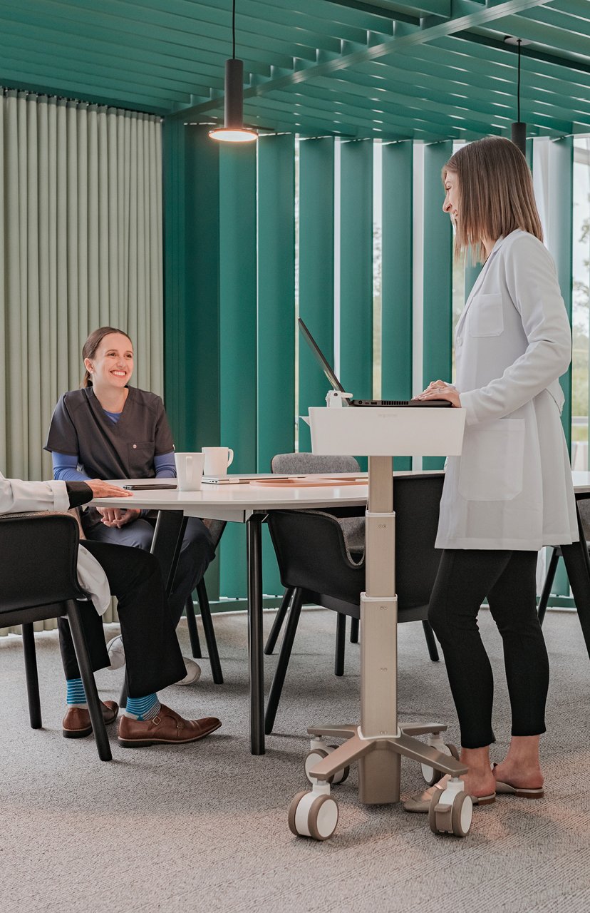 Healthcare professionals using height adjustable workstation in a pergola workspace