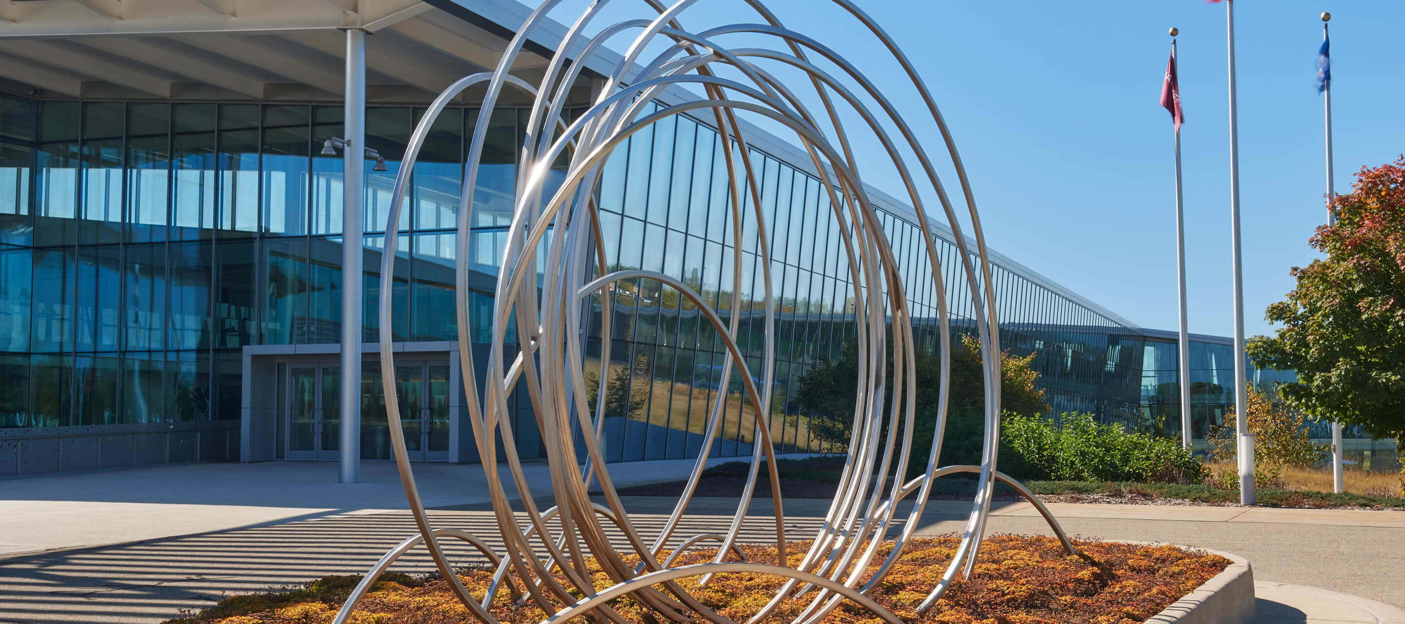 View outside of One Haworth Center with large metal circular sculpture.