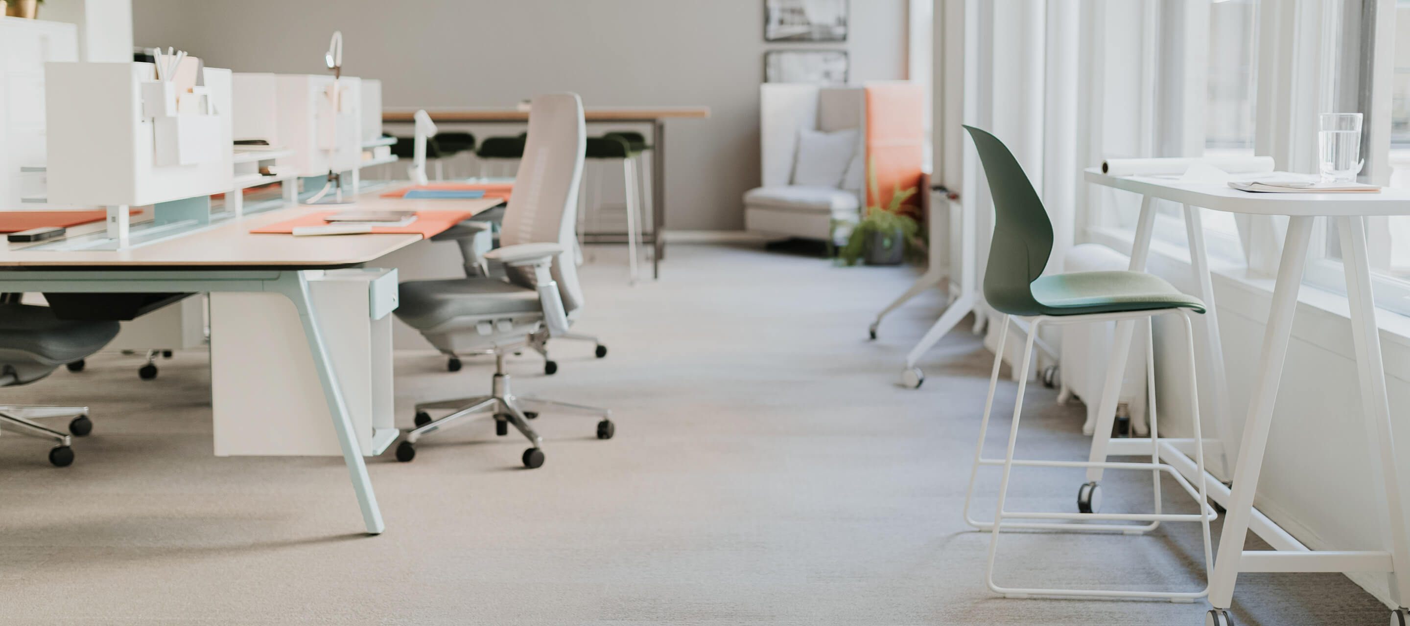 Individual workspace featuring a gray fern office chair  and maari chair with popup table/