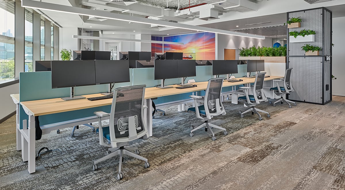 The traders' workspaces offer height-adjustable desks that encourage people to change postures throughout the day. Dual monitors reduce eye strain. Acoustic partition screens add comfort and privacy.  