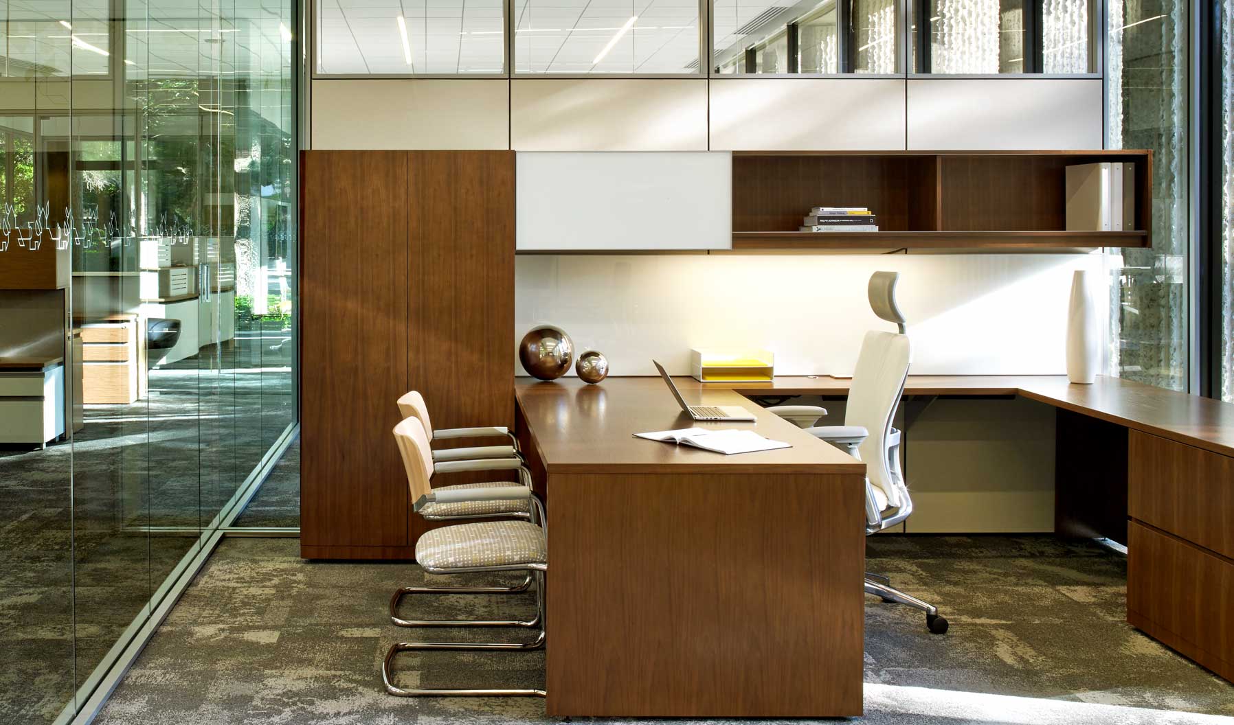 This traditional private office supports both focused, heads-down work as well as transactional interaction with guests. Additionally, it provides both open and enclosed storage, as well as surfaces to annotate and pin up. The use of glass connects this c-suite positioned private office to the greater office environment.