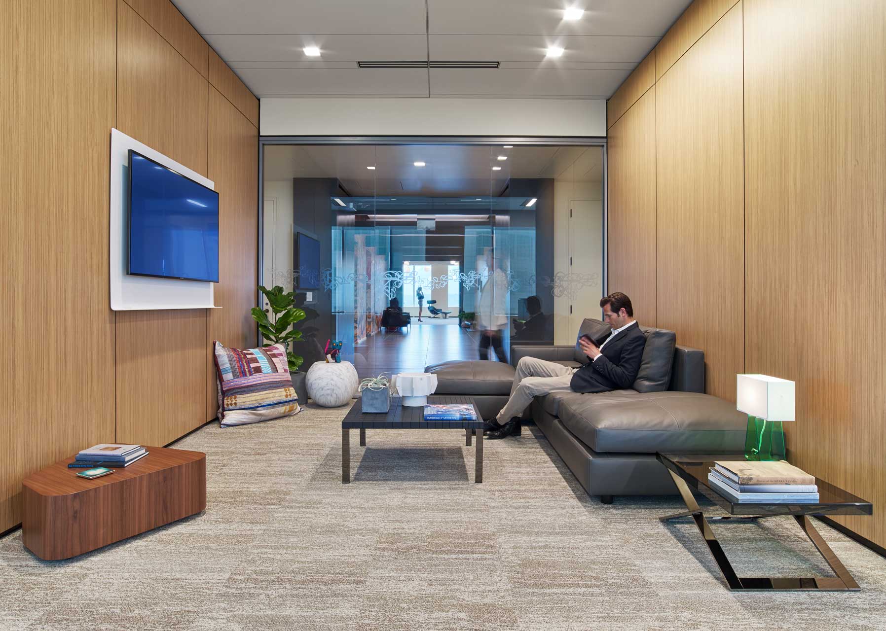 The relaxed, seated posture of the furniture in this retreat create an opportunity to recharge or fosters collaboration in a lounge setting leveraging technology. The leather sofa and the wood walls help create warmth in an open office environment.