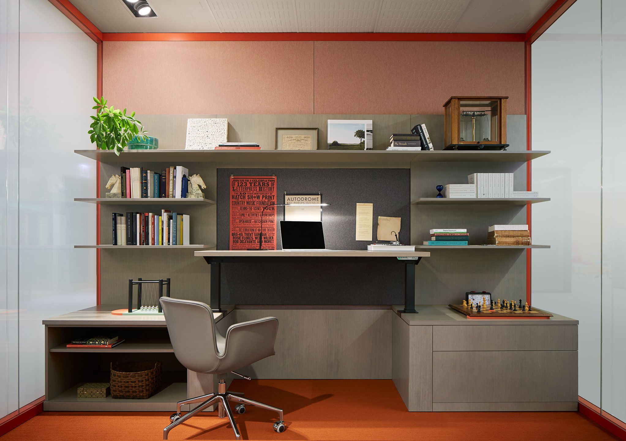 Haworth Masters Series Workspace in private office space with height adjustable desk and shelves with books and chair