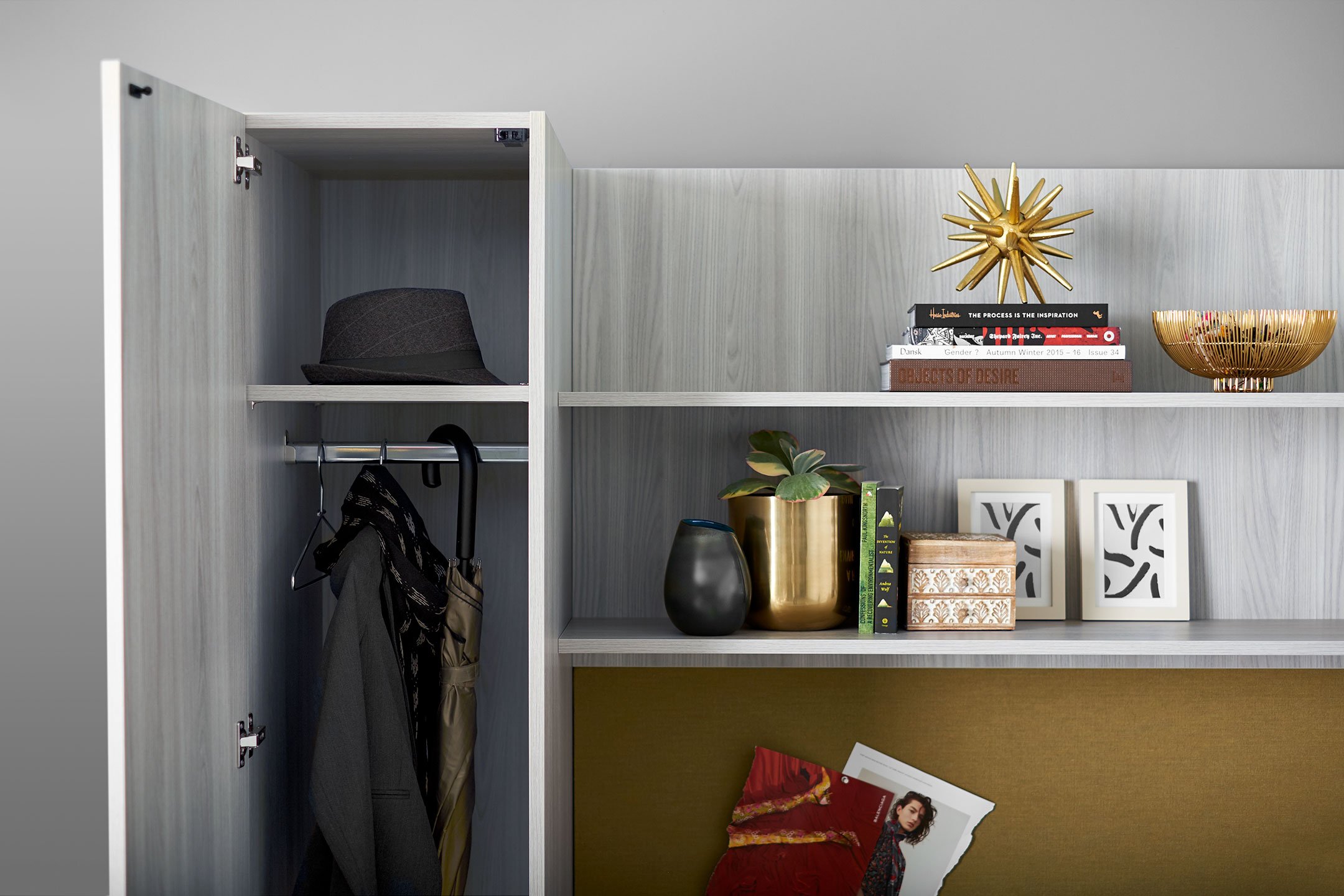 Haworth Masters Series Workspace in grey veneer showing an open coat closet and shelves with photos and books on them with a corkboard beneath