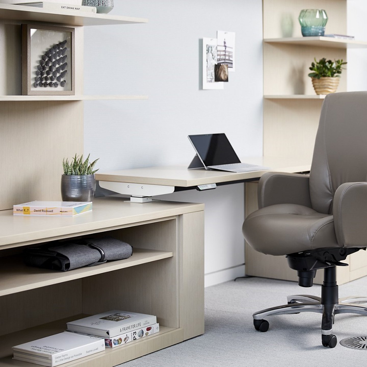 Haworth Masters Series Workspace Veneer height adjustable desk in private office space and grey chair with shelving unit