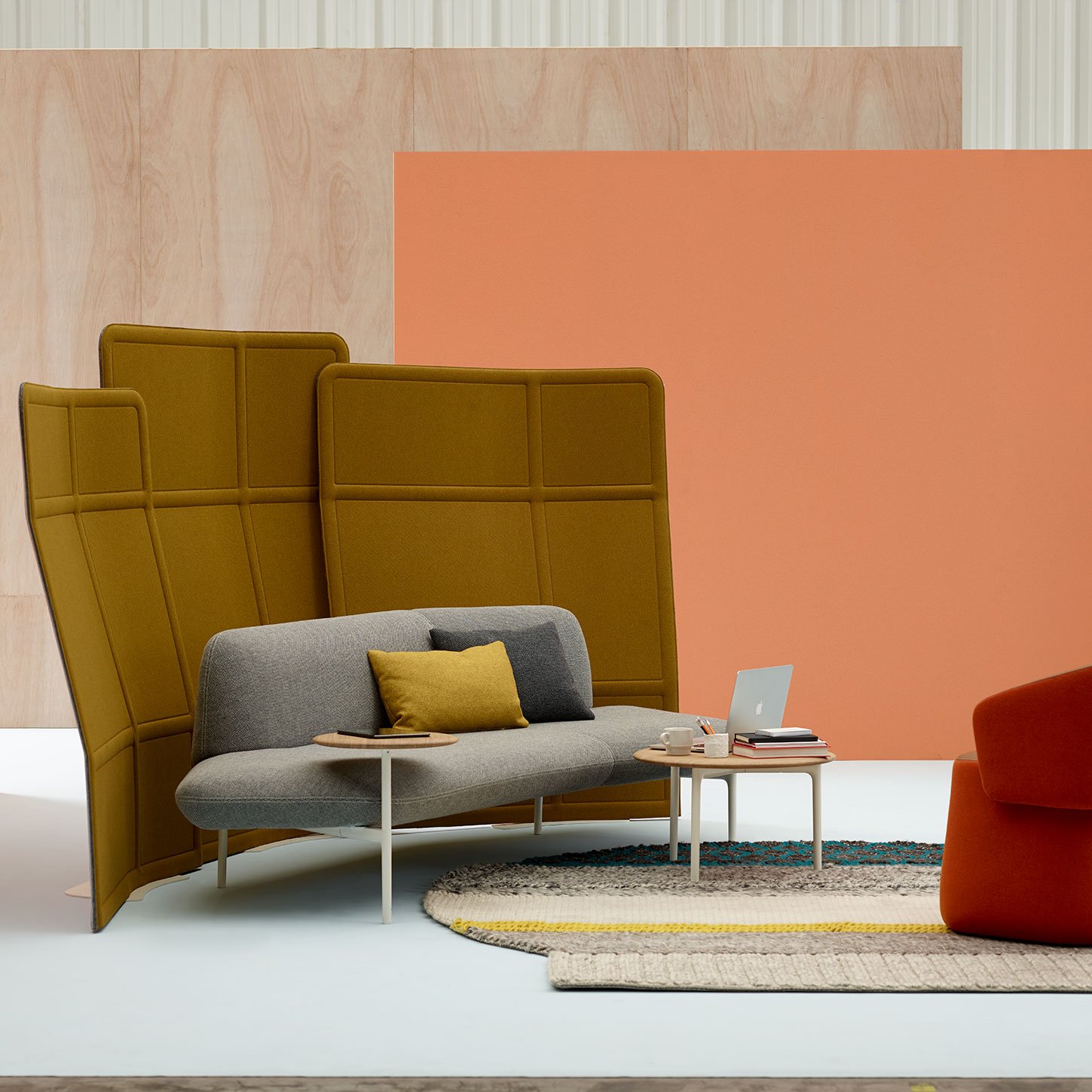 Haworth Openest Plume Screen in orange color over grey couch in open space
