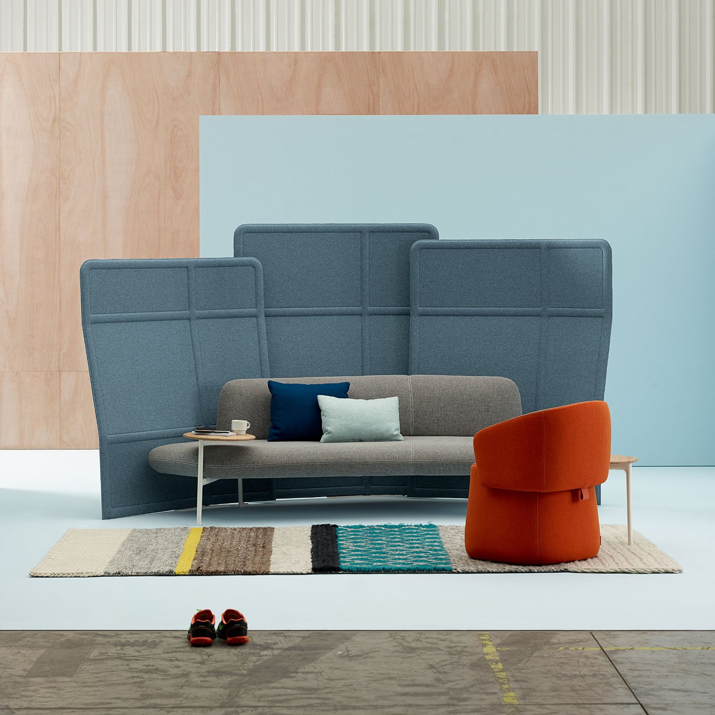 Haworth Openest Plume Screen in blue color above grey couch in orange chair in open space