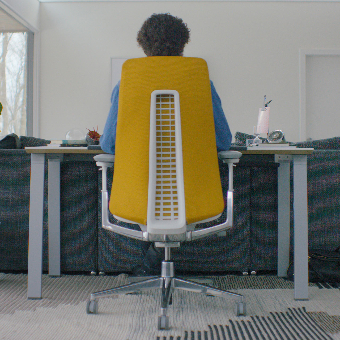 Haworth Fern desk chair in yellow upholstery placed at a individual desk in a room