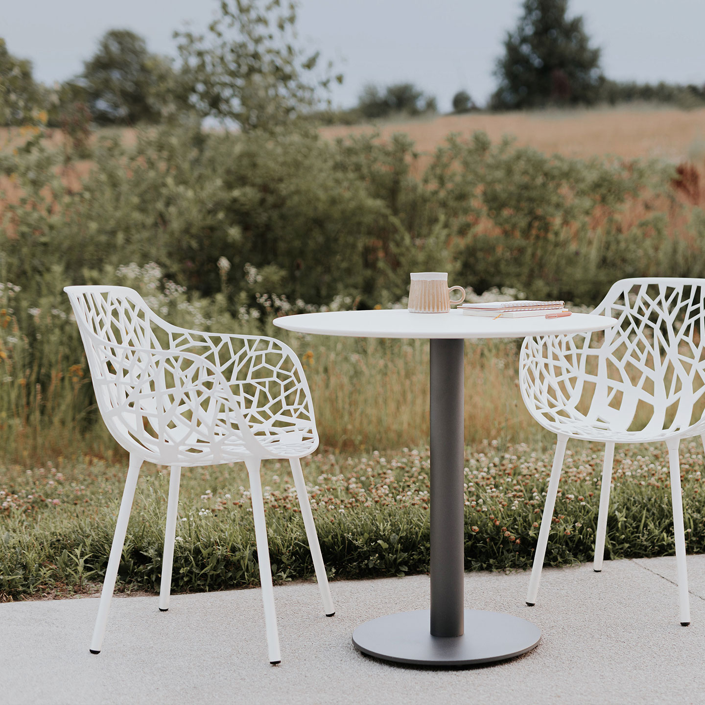 Haworth Janus Cafe Table in white laminate in outdoor patio seating in a coffee table conversation set up