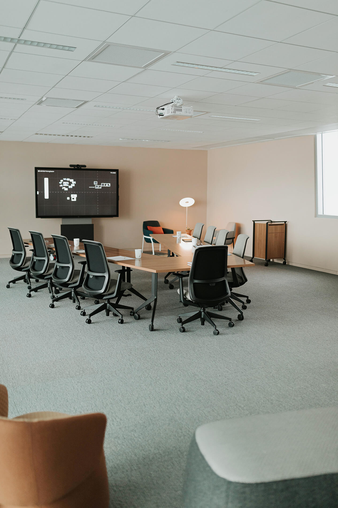 Haworth Planes Training table with maple top in a meeting room with a monitor and haworth chairs